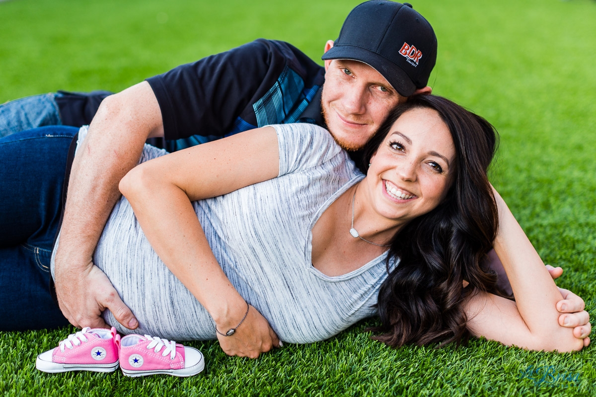 lying down maternity with father smiling at camera