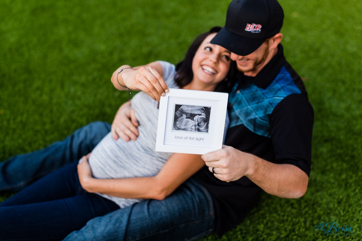 laying down grass holding ultrasound maternity