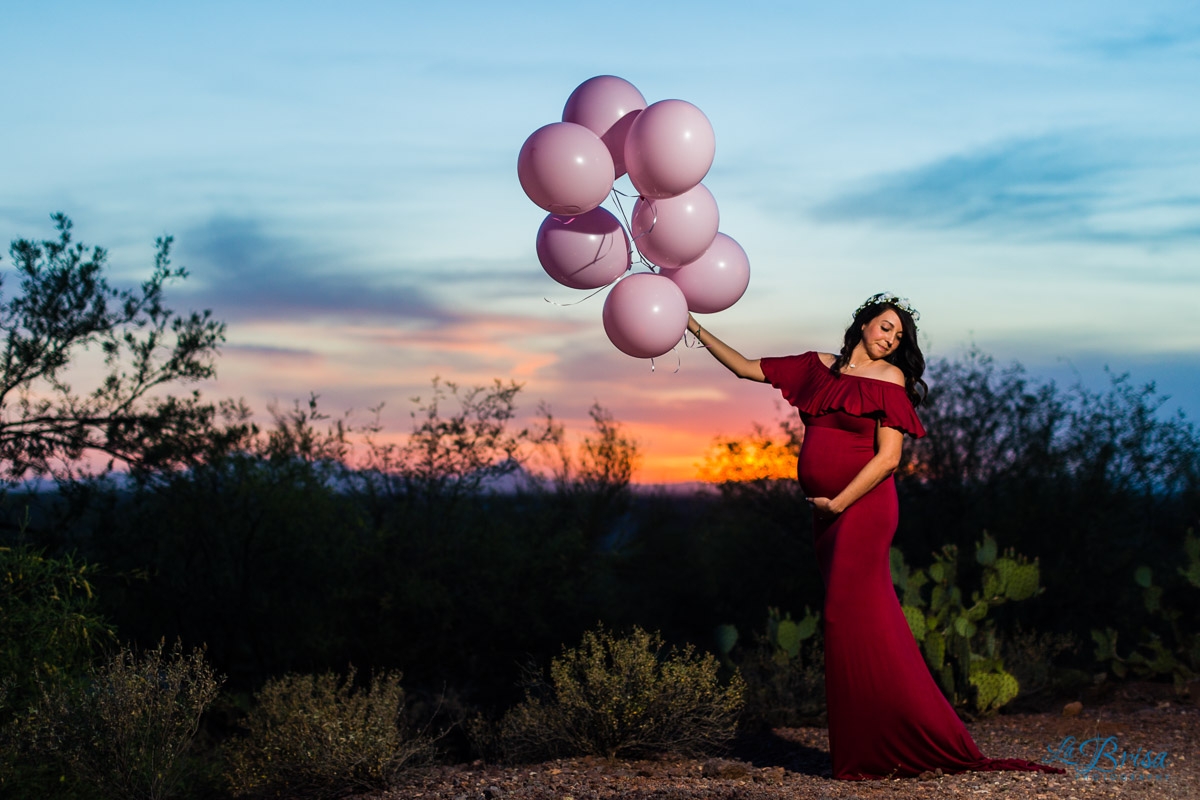 pink balloons red flowing maternity dress desert sunset