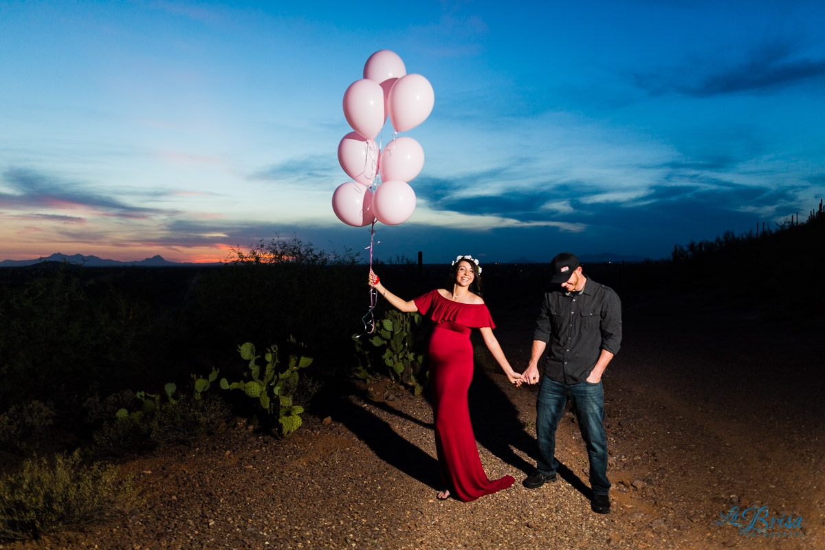 pink balloons gender reveal red maternity dress