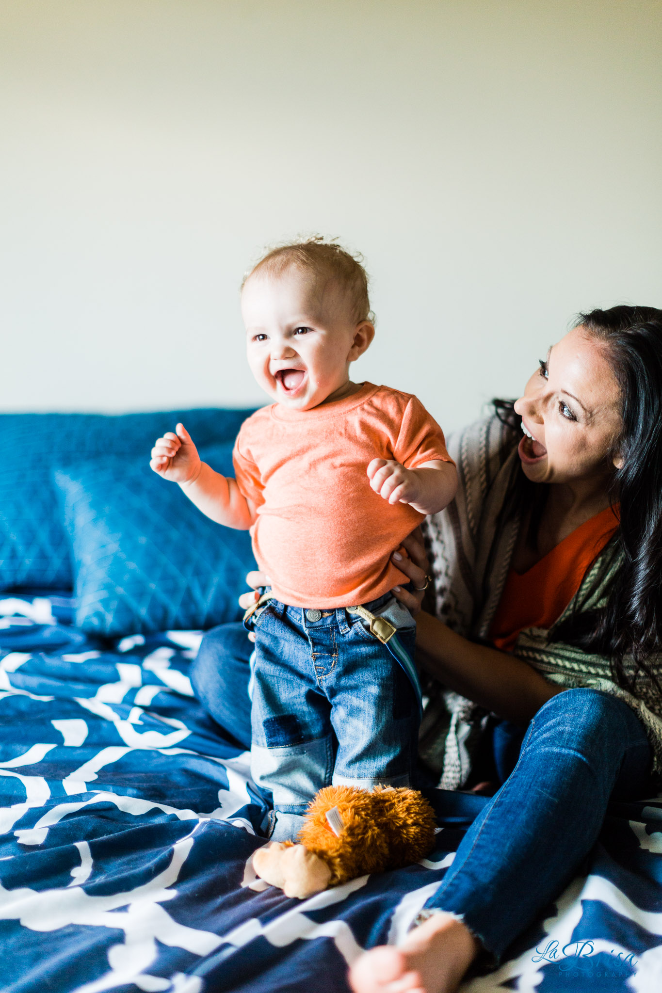 baby boy playing on bed with mom