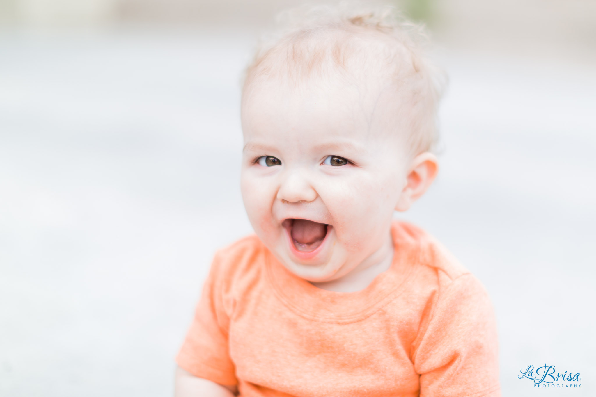 baby boy smiling orange shirt