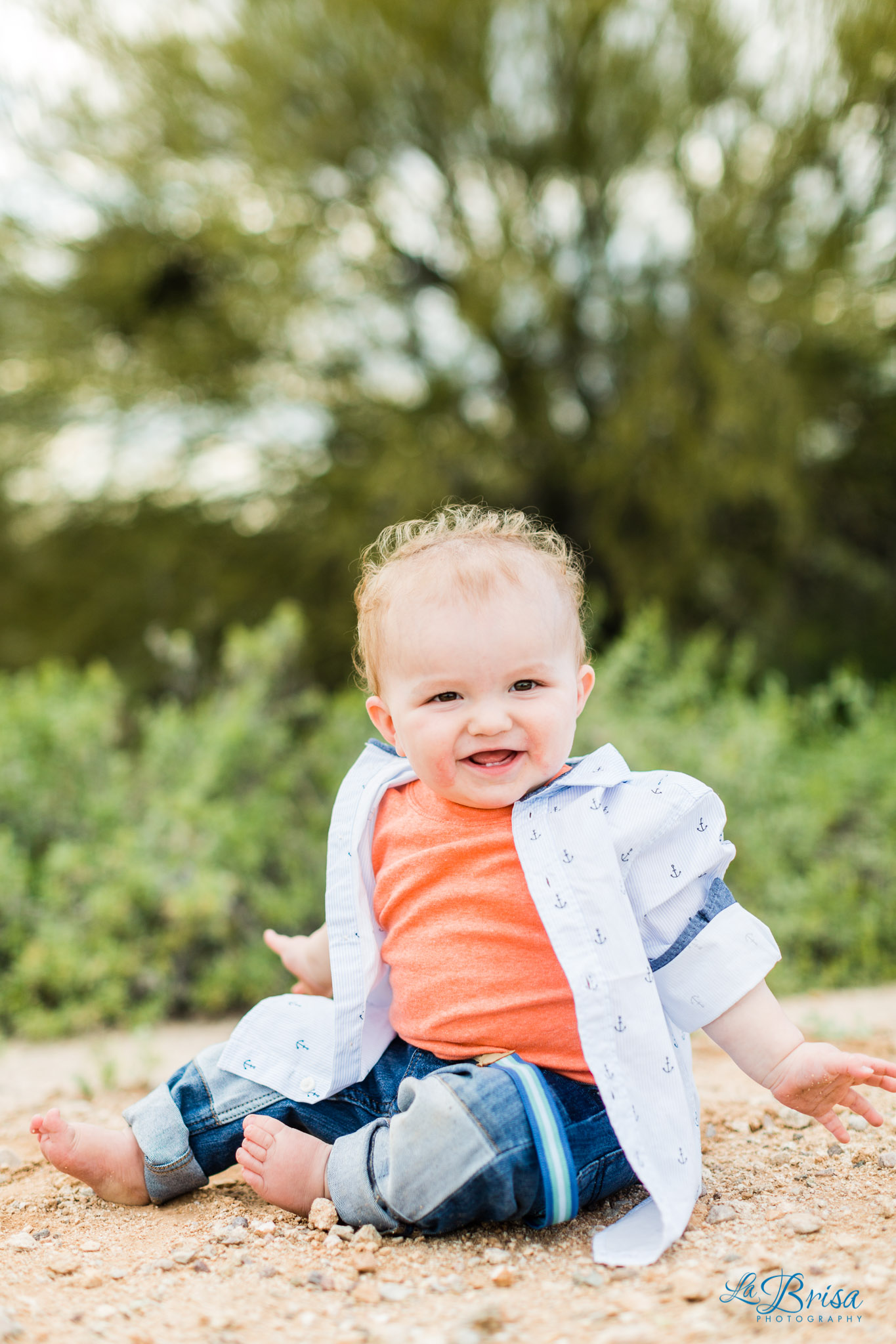 one year old boy sitting in desert